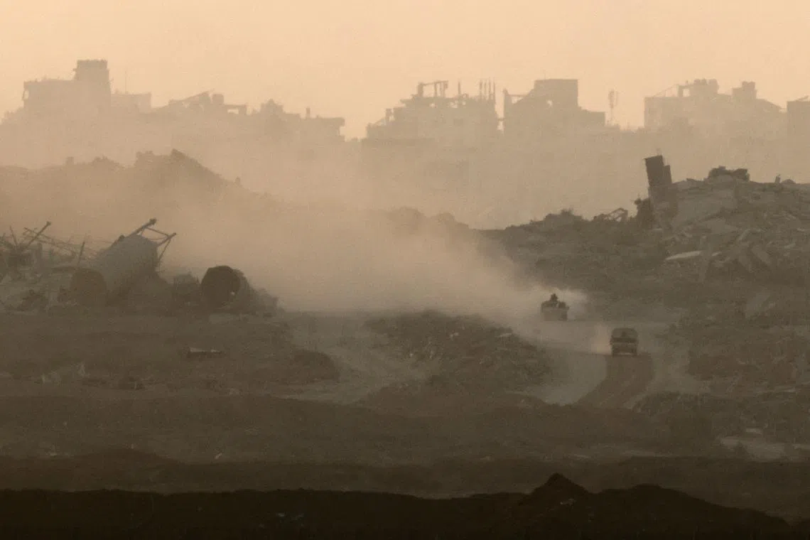 Israeli military vehicles manoeuvre in Gaza, as seen from the Israeli side of the Israel-Gaza border, July 21, 2025. REUTERS/Amir Cohen/File Photo