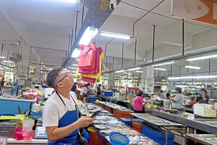 A fishmonger looking at the CCTV he installed at his stall at the Batu Lanchang market in George Town, Penang. 