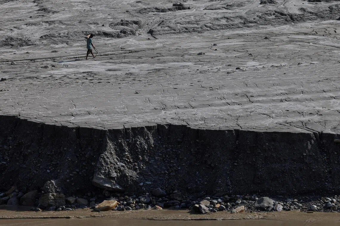 A man walks along a mud-covered riverbank following deadly flash floods and mudslides, in Dhading district, Nepal, September 14, 2026. REUTERS/Tyrone Siu     TPX IMAGES OF THE DAY     