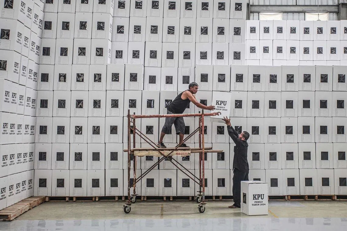 TOPSHOT - Officers stack ballot boxes ahead of Indonesia's upcoming general election scheduled to be held on February 14, 2024, at a warehouse of the General Election Commission in Palembang, South Sumatra, on December 20, 2023. (Photo by Al ZULKIFLI / AFP)
