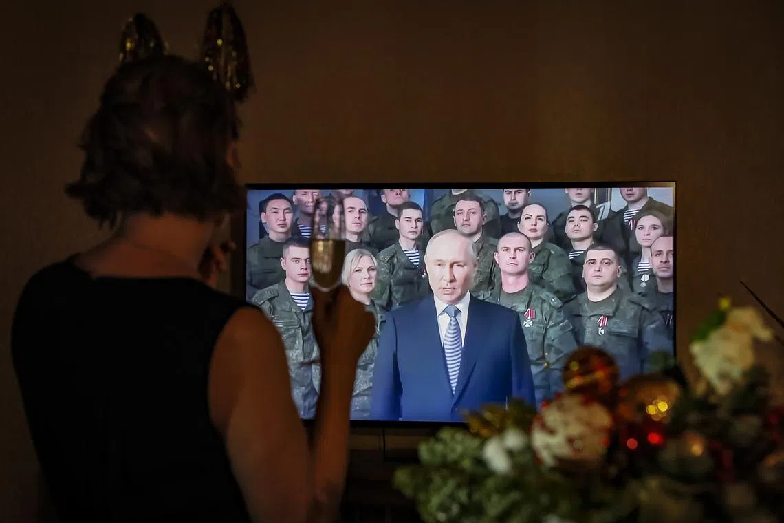 epa10384383 A woman listens to the Russian President Vladimir Putin annual New Year's address to the nation in their home in Moscow, Russia, 31 December 2022.  EPA-EFE/YURI KOCHETKOV