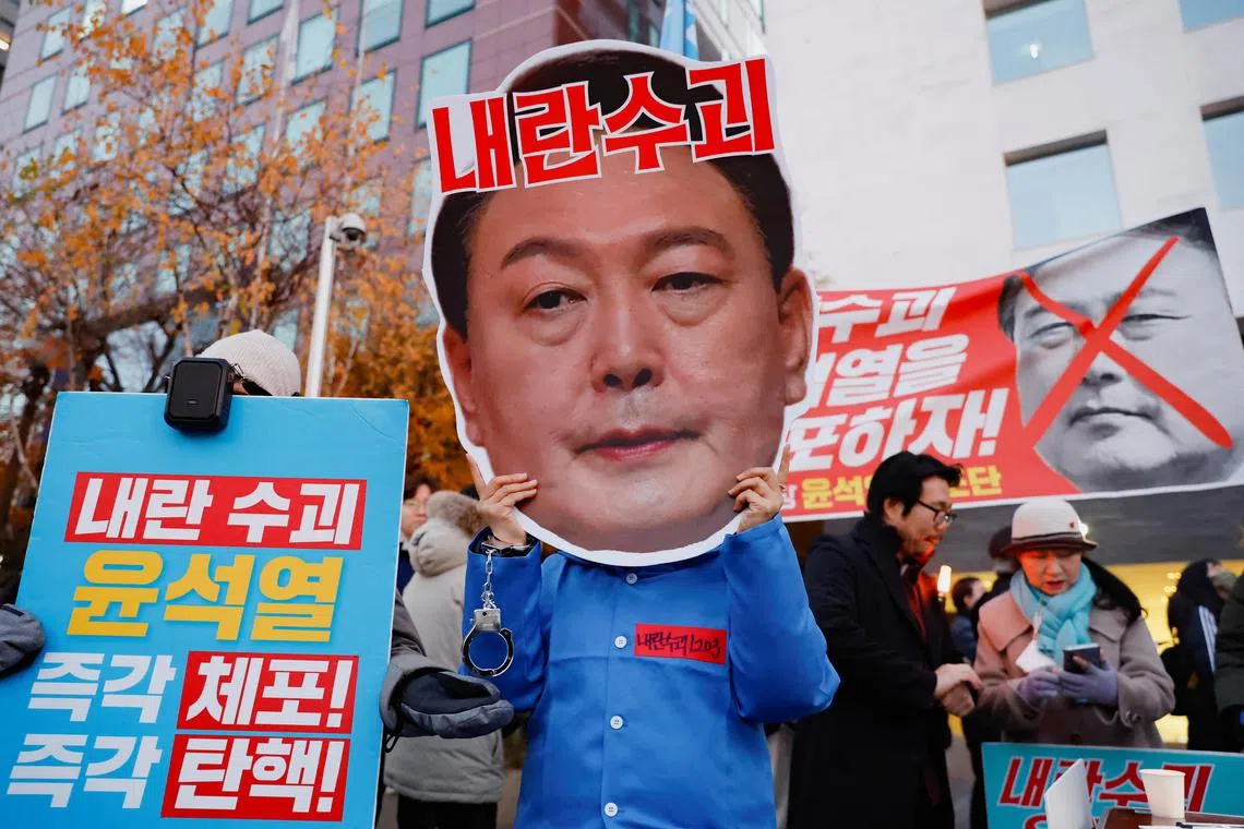 A protestor wears a face mask of South Korean President Yoon Suk Yeol in a rally calling for his impeachment in Seoul, South Korea, on Dec 8, 2024. 