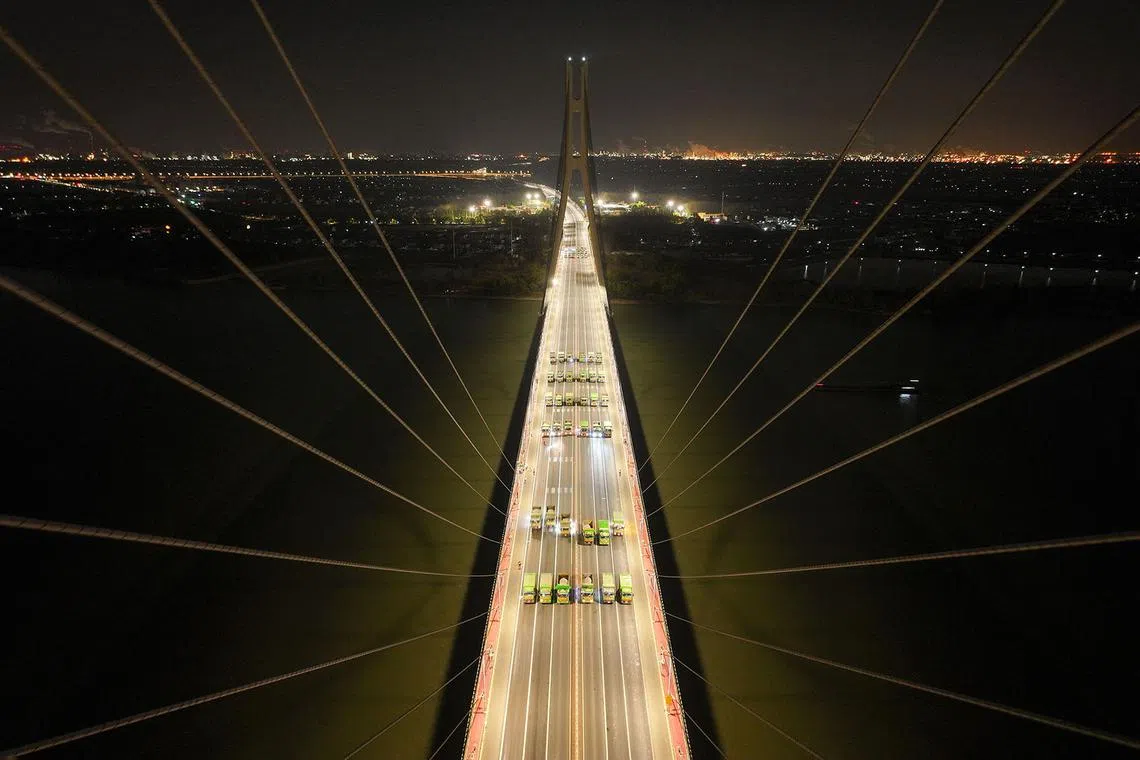 TOPSHOT - Loaded trucks drive on the Baguazhou Yangtze river bridge for a safety test inspection in Nanjing, China's eastern Jiangsu province on December 18, 2024. (Photo by AFP) / China OUT