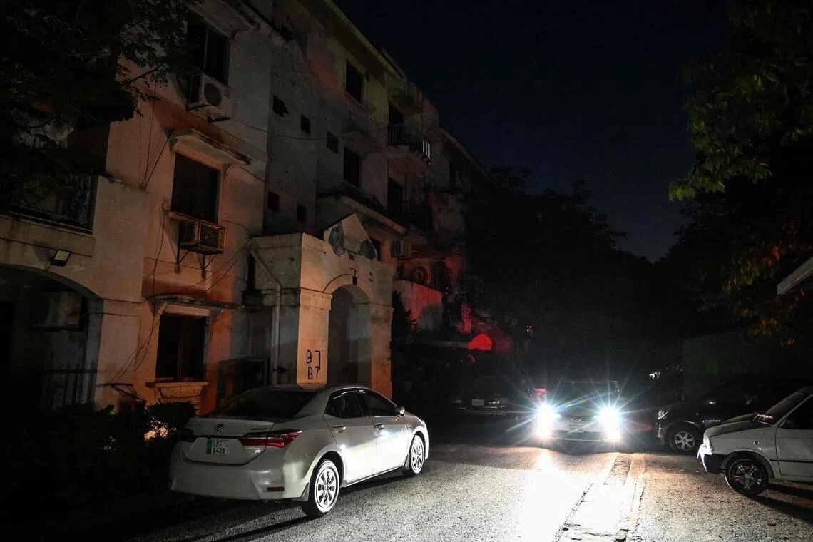 A motorist rides past an apartment during a power cut in Islamabad on April 15. 