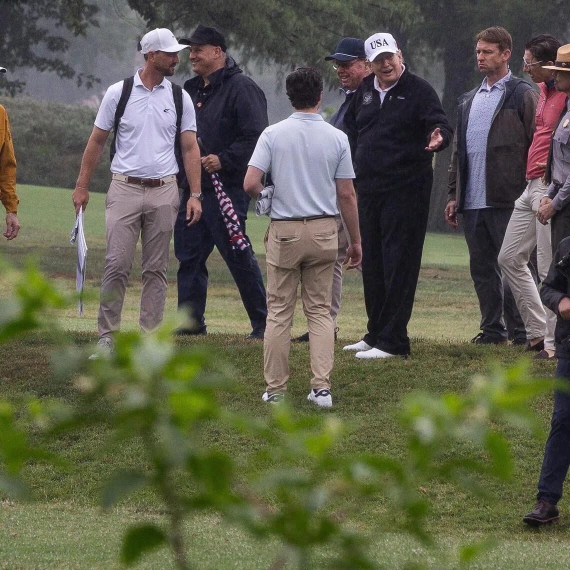 US President Donald Trump (centre right) and US Secretary of the Interior Doug Burgum (left) walk at the East Potomac Golf Links during a site tour in Washington DC, on June 28.