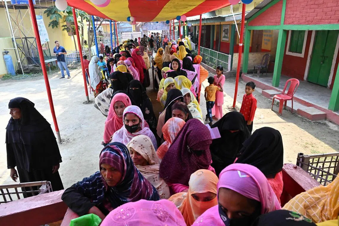 Voters queue up to cast their ballot at a polling station during the second phase of voting of the India's general election at Sidhaguri village in Morigaon district of Assam state on April 26, 2024.