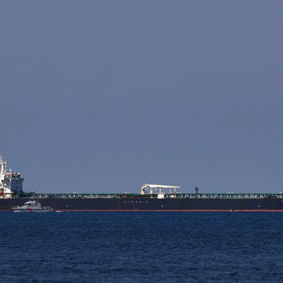 FILE PHOTO: A French Maritime Gendarmerie boat patrols around the Mozambique-flagged oil tanker named Deyna, which France says is part of Russia's shadow fleet, off the port of Marseille-Fos in the Gulf of Fos-sur-Mer, near Martigues, France, March 23, 2026. REUTERS/Manon Cruz/File Photo