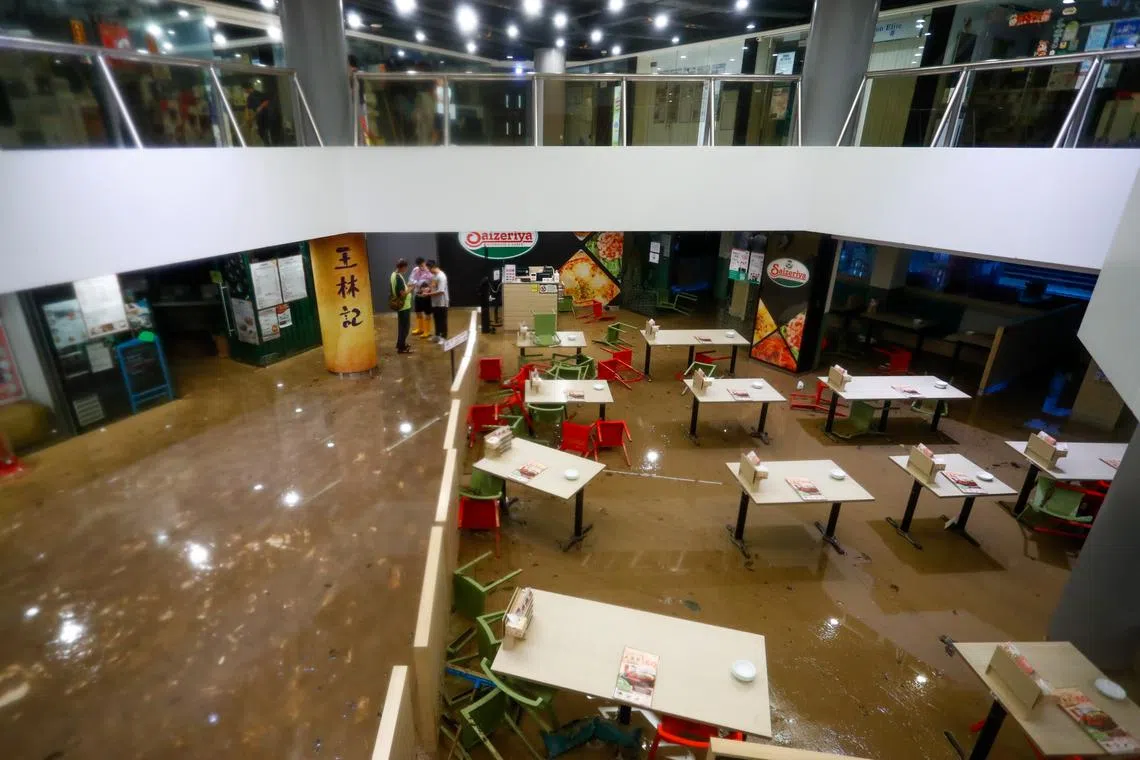 People are seen at a flooded shopping Center following continued torrential rains hitting the city, in Hong Kong, China, on Sept 8, 2023. 