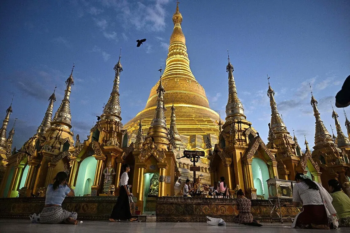 TOPSHOT - People pay their respects at Shwedagon Pagoda in Yangon on December 29, 2025, a day after the first phase of Myanmar's general election. (Photo by Lillian SUWANRUMPHA / AFP)