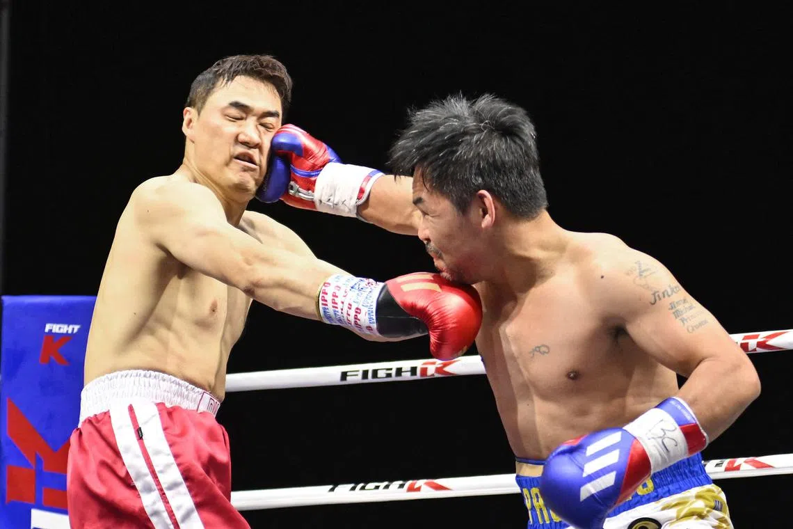 Manny Pacquiao (R) of the Philippines fights against DK Yoo of South Korea during their exhibition boxing match in Goyang, northwest of Seoul, on December 11, 2022. (Photo by Jung Yeon-je / AFP)