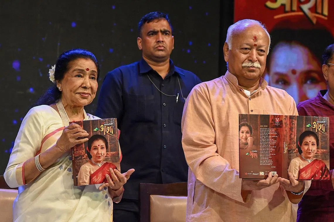 Rashtriya Swayamsevak Sangh (RSS) chief Mohan Bhagwat (R) attends the book launch of Indian playback singer Asha Bhosle (L) in Mumbai on June 28, 2024. (Photo by SUJIT JAISWAL / AFP)