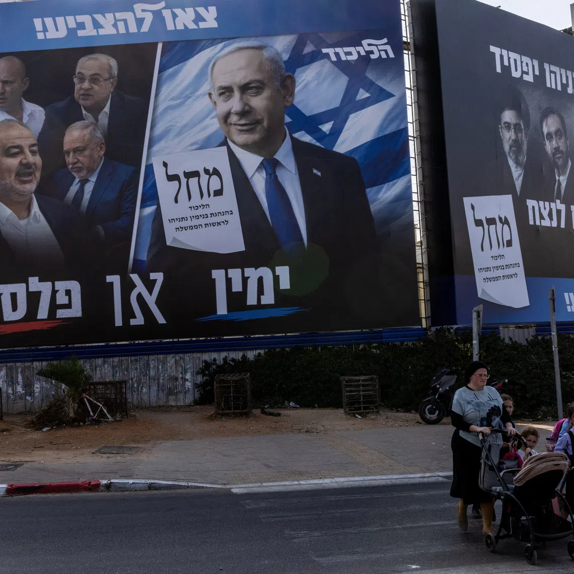 People walk next to a campaign banner of Netanyahu's Likud party, ahead of the Israeli parliamentary election, in Bnei Brak, Israel, October 25, 2026. REUTERS/Nir Elias