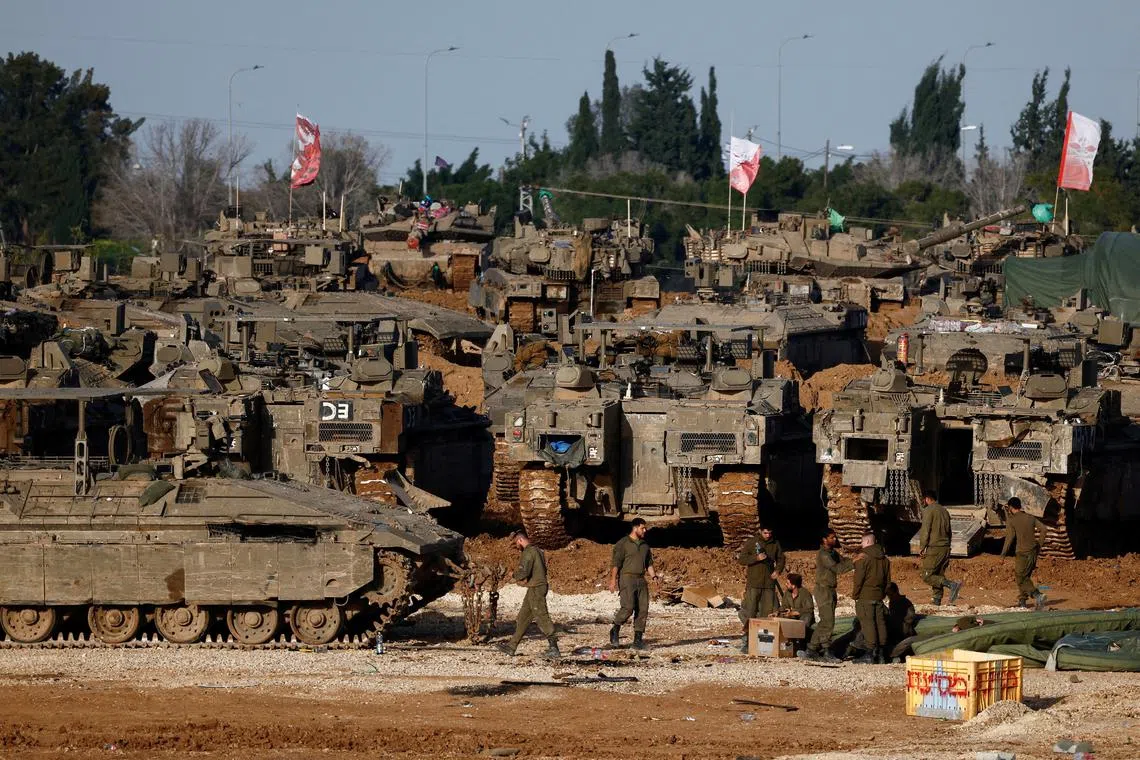 Israeli soldiers work by military vehicles, amid a ceasefire between Israel and Hamas, near the border with Gaza, in Israel, February 15, 2025. REUTERS/Amir Cohen/File Photo