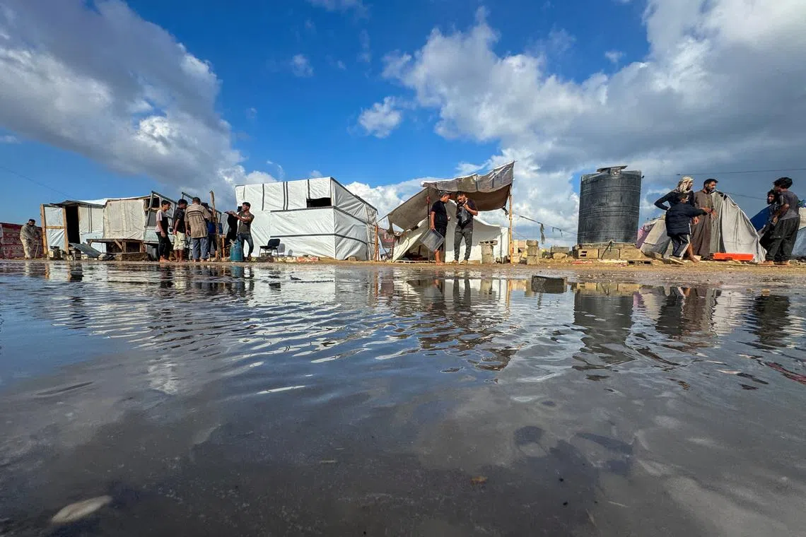Displaced Palestinians gather as they shelter in a tent camp which was flooded following rainfall, amid the Israel-Hamas conflict, in Khan Younis, in the southern Gaza Strip, September 22, 2024. REUTERS/Mohammed Salem/File Photo