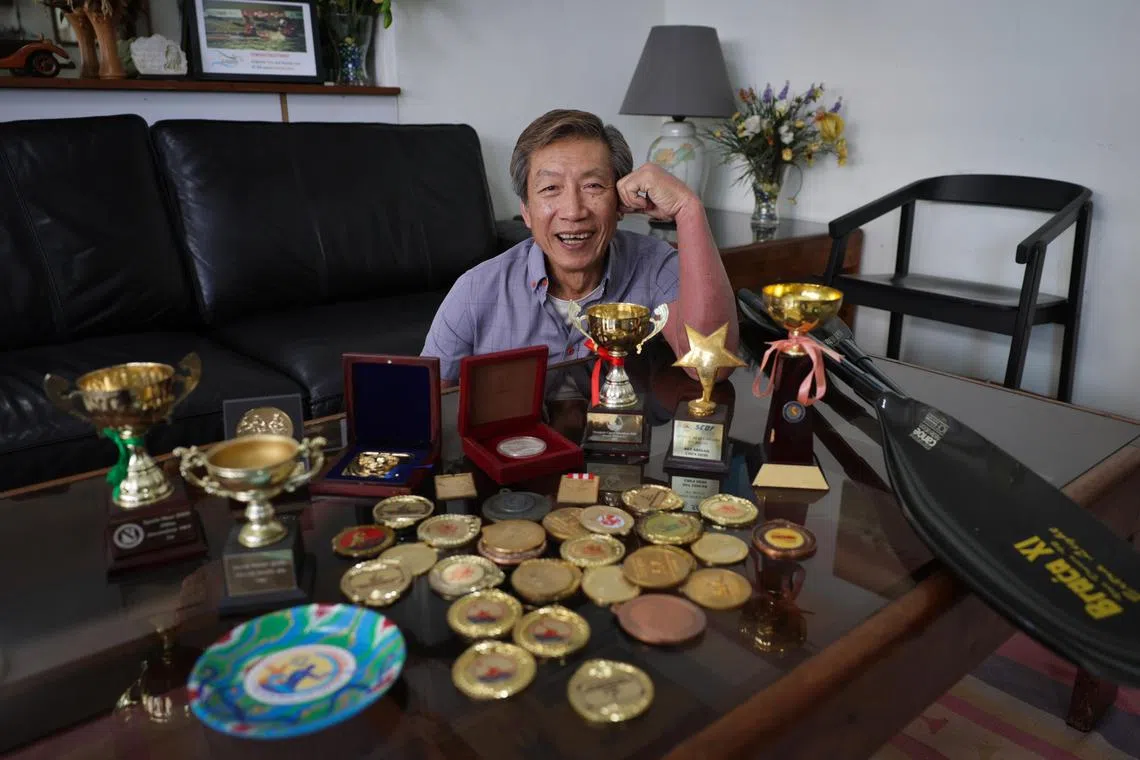 Taxi driver Michael Chen with some of the medals his children have won over the years. His daughter, Stephenie, will be kayaking in the Olympics.  ST PHOTO: GIN TAY