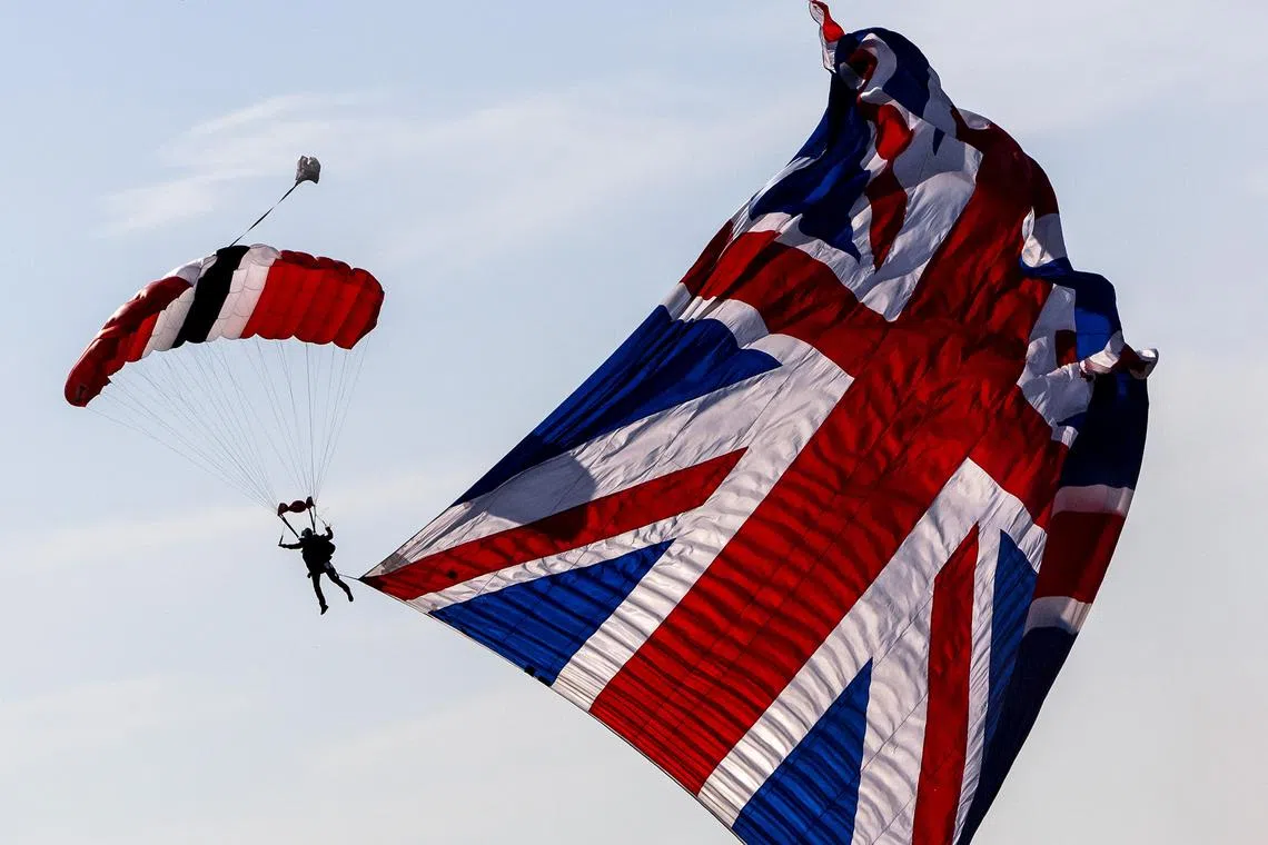 A paratrooper landing with a huge British flag on the Ginkelse Heide, during the commemoration of Operation Market Garden, in Ede, the Netherlands, on Sept 21.