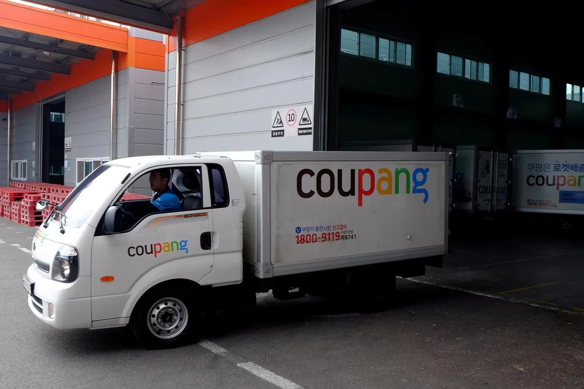 FILE PHOTO: Delivery trucks for e-commerce retailer Coupang leave a distribution centre in Seoul, South Korea, June 21, 2018. Picture taken June 21, 2018. REUTERS/Josh Smith/File Photo