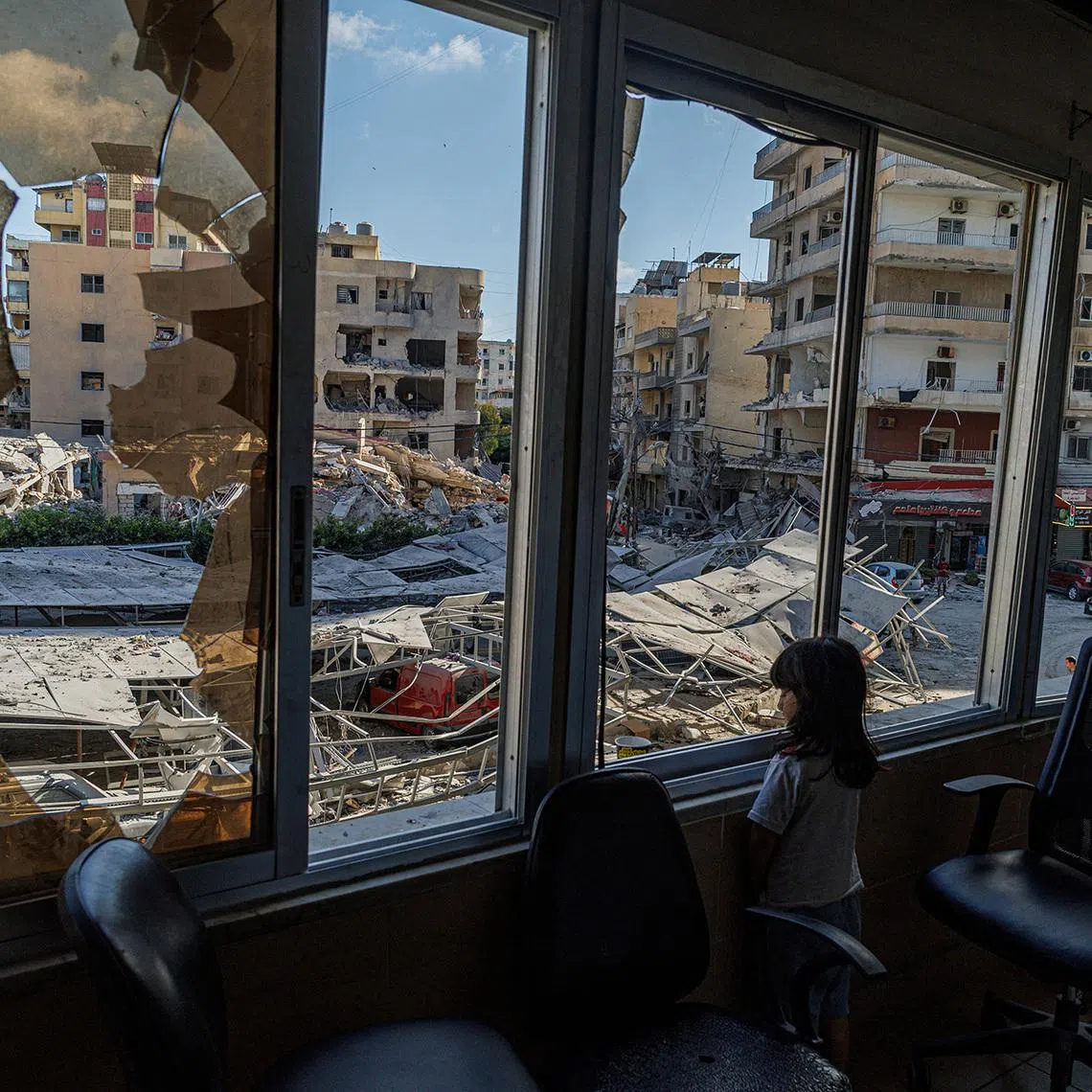 A displaced girl looks out from Jabal Amel Hospital towards buildings damaged by Israeli strikes in Tyre, southern Lebanon. 