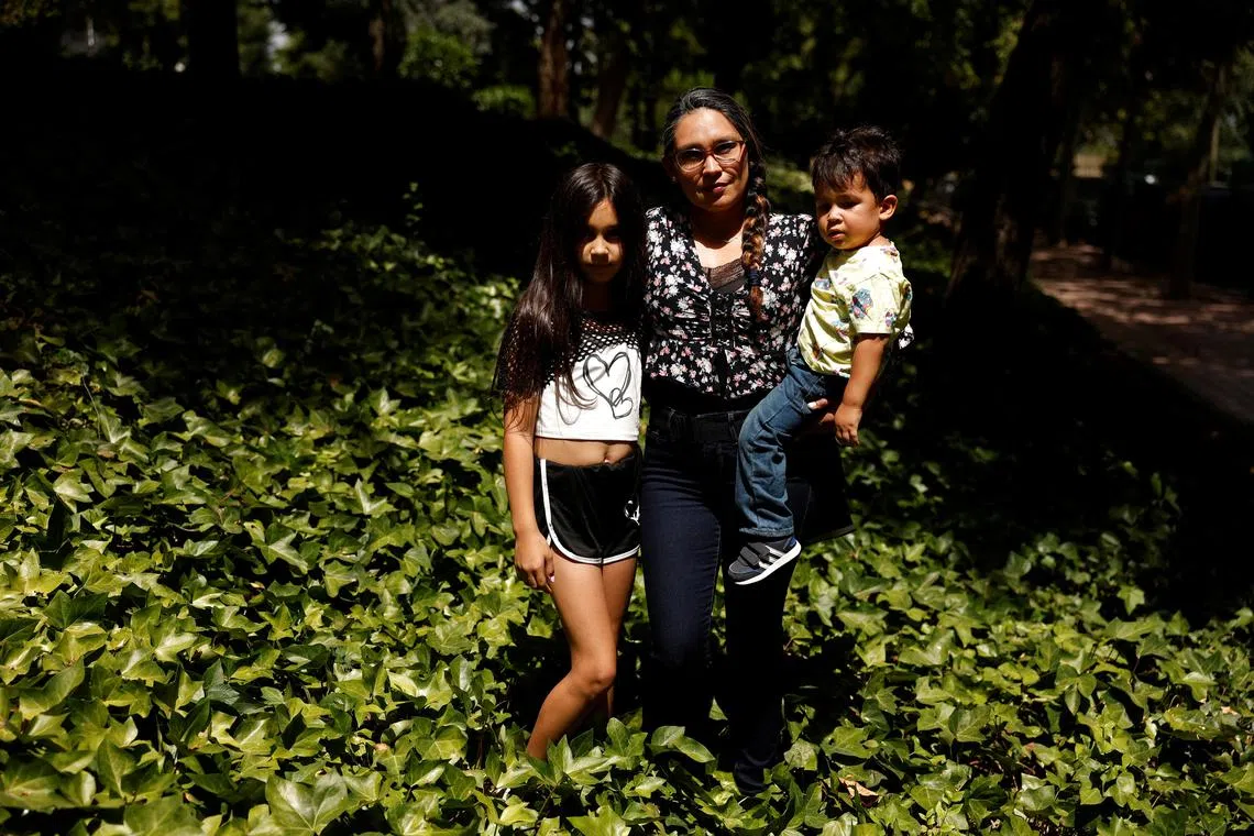 Meliana Bruguera, 41, poses with her children Victoria, 9, and Rurik, 2, before an interview with Reuters in Alcorcon, outside Madrid, Spain August 8, 2025. REUTERS/Susana Vera