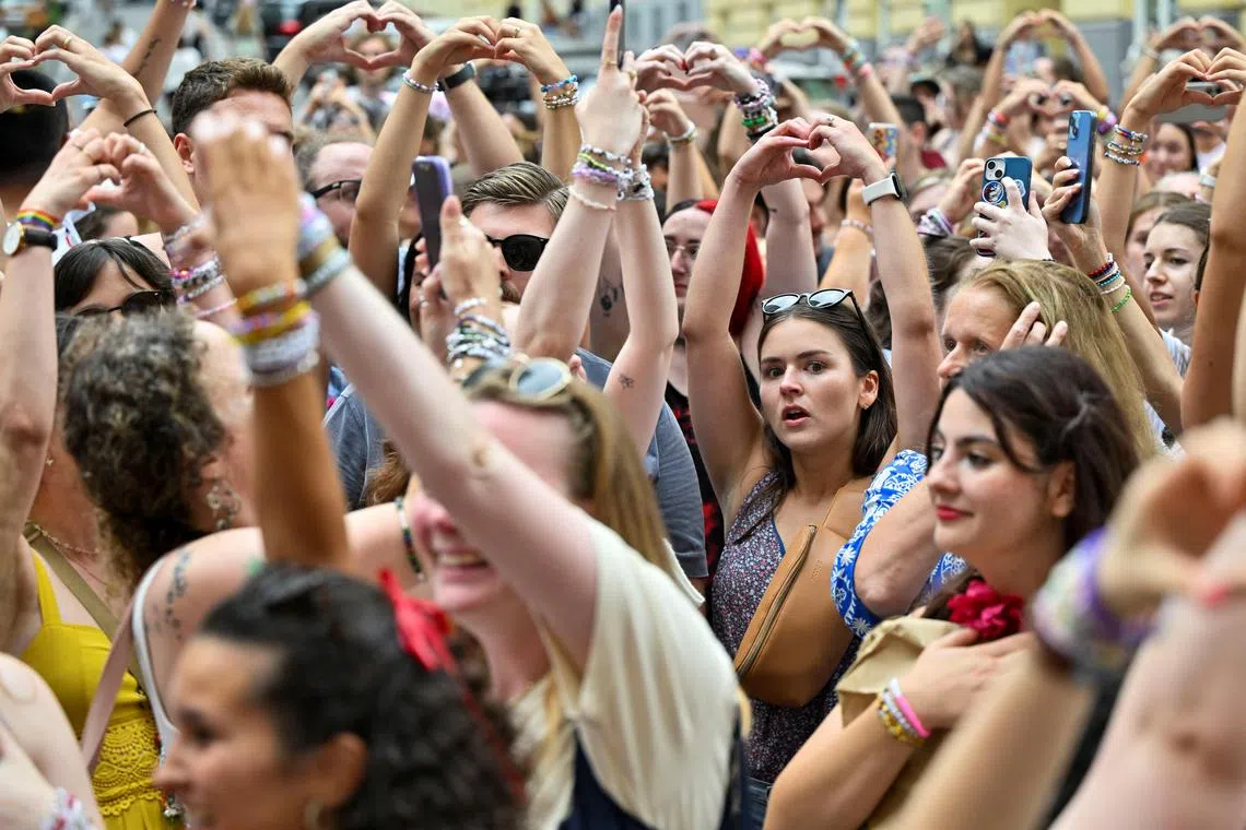 Taylor Swift fans making heart shapes with their hands, after gathering in Vienna following the cancellation of the US singer's concerts in the city.