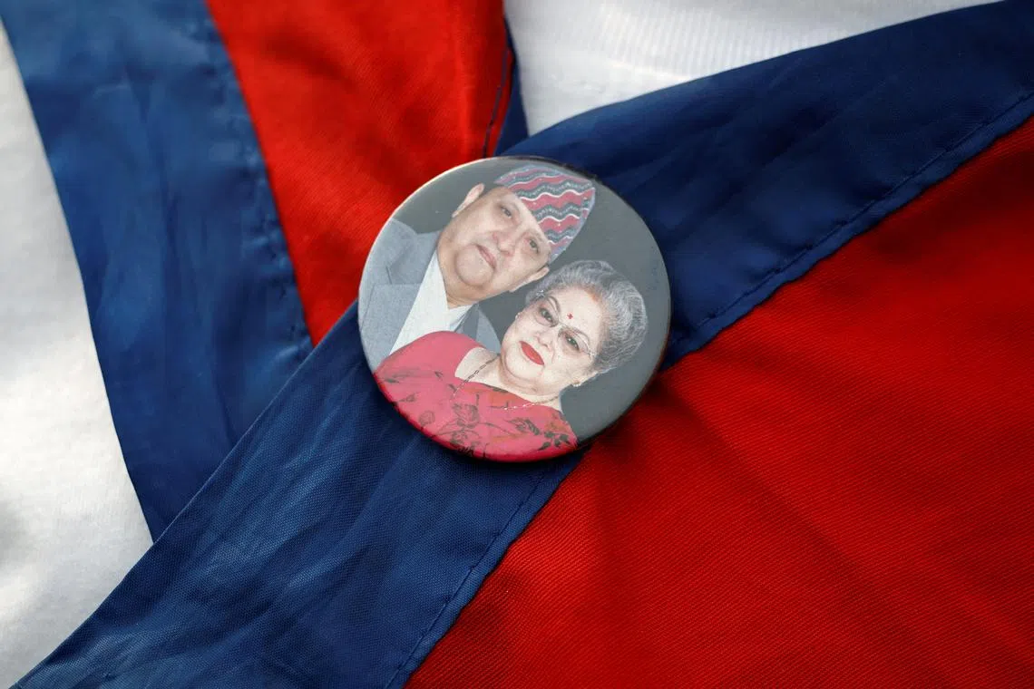 FILE PHOTO: A Pro-monarchy supporter affiliated with Rastriya Prajatantra Party (RPP) with a badge of former King of Nepal Gyanendra Bir Bikram Shah Dev and former Queen Komal Rajya Laxmi Devi Shah takes part during a protest demanding the restoration of constitutional monarchy in Kathmandu, Nepal April 8, 2025. REUTERS/Navesh Chitrakar/File Photo