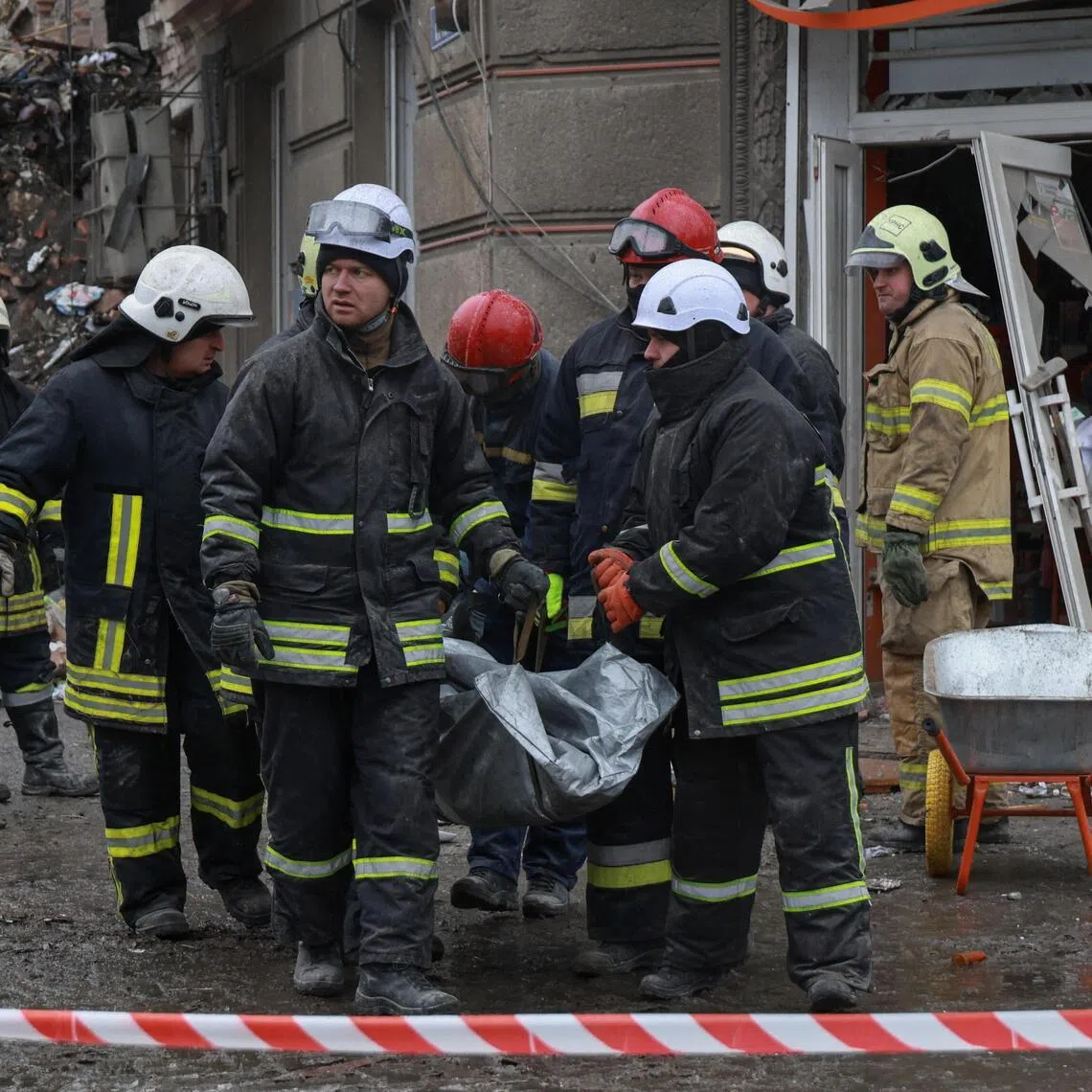 Ukrainian rescuers carrying the body of a person who was found under the debris of a residential building in Odesa on Jan 27, following overnight Russian strikes on the city.