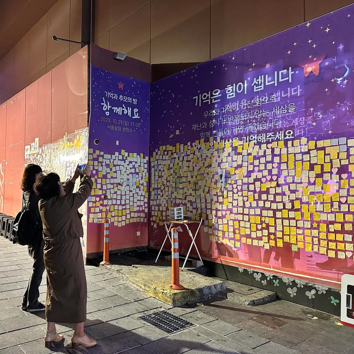 People taking photos of a memorial in October 2023 to remember Halloween revellers killed in 2022 in Seoul’s Itaewon district.