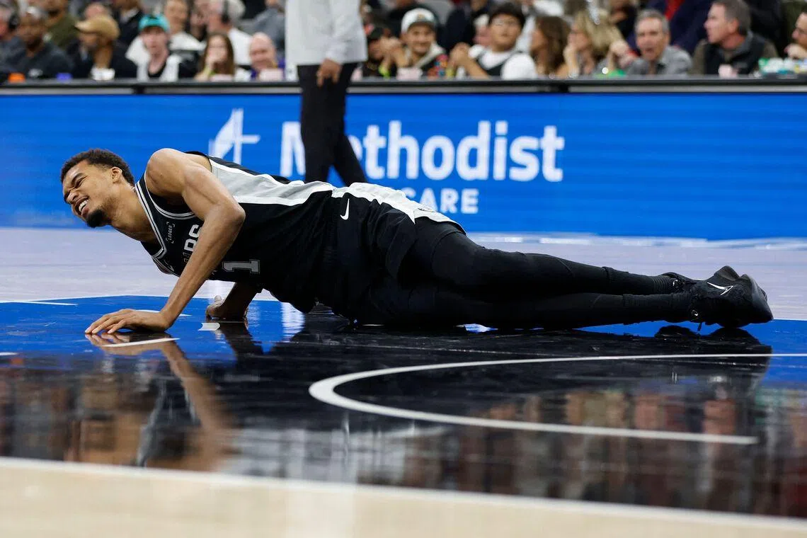 Victor Wembanyama lies on the court in the second half against the New York Knicks at Frost Bank Center.