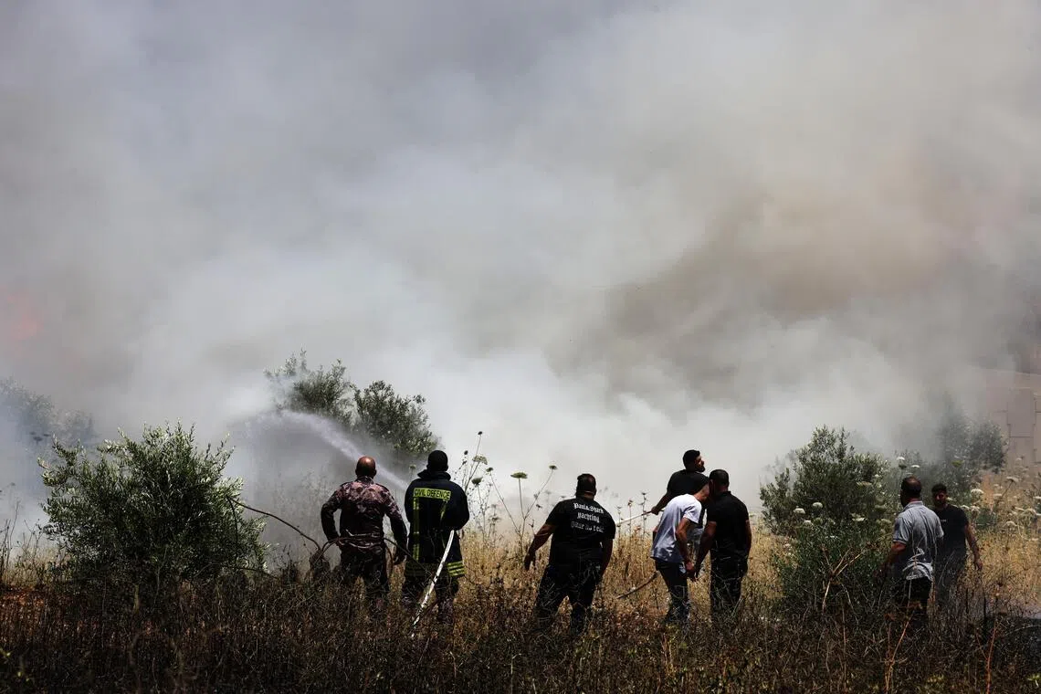 Palestinians trying to extinguish smouldering farms, following an attack by Israeli settlers in the village of Huwwara, near Nablus, in the West Bank, on June 6.