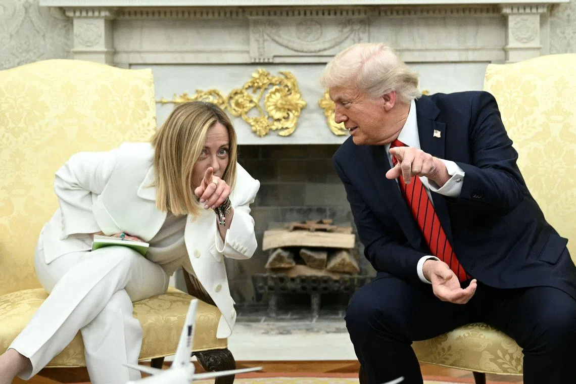 TOPSHOT - US President Donald Trump meets with Italian Prime Minister Giorgia Meloni as Vice President JD Vance (R) looks on in the Oval Office of the White House in Washington, DC, on April 17, 2025. Italy's Prime Minister Giorgia Meloni meets with Donald Trump Thursday in Washington, hoping a personal charm offensive can help convince the US president to cut a more favourable deal on EU tariffs. (Photo by Brendan SMIALOWSKI / AFP)