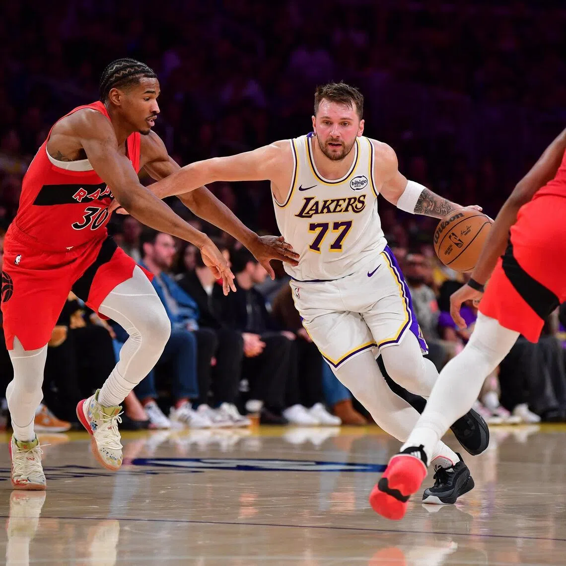 Los Angeles Lakers guard Luka Doncic dribbling against Toronto Raptors guard Ochai Agbaji and forward Collin Murray-Boyles during the Lakers' 110-93 NBA win on Jan 18.