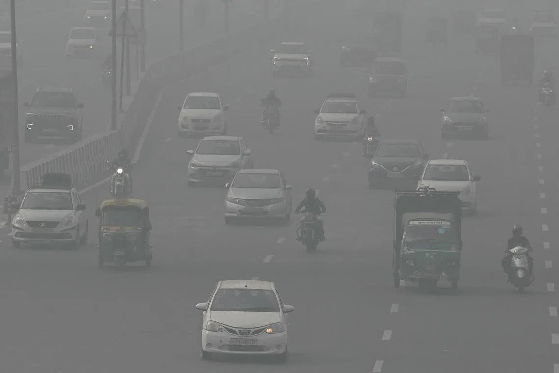 Commuters making their way along a road amid heavy smoggy conditions in New Delhi on Nov 5, 2023. 