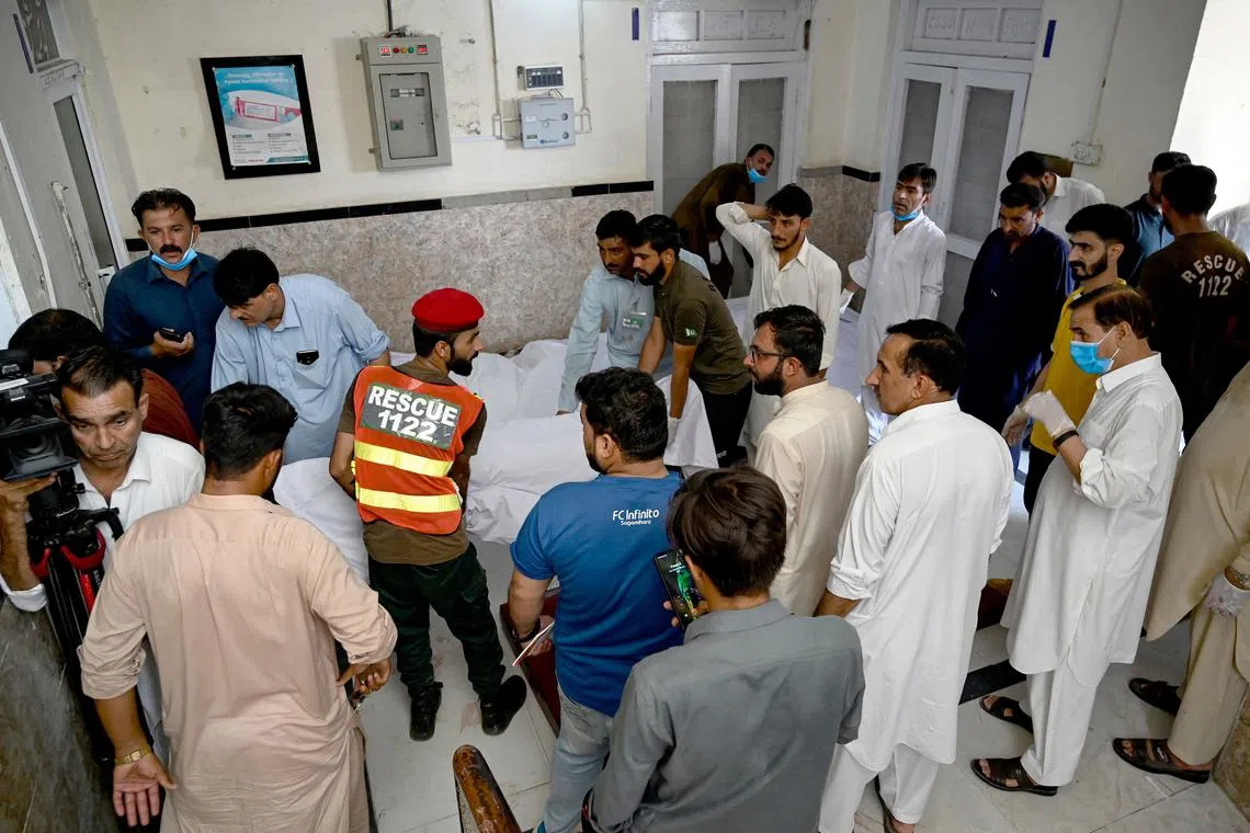 Paramedics and rescue workers carry the bodies of bus accident victims at a hospial in Kahuta, Punjab province on Aug 25.