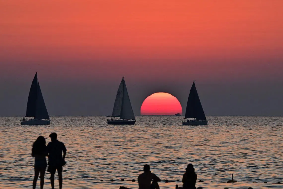 Boats sailing at sunset in the Gulf emirate of Dubai, on March 19, 2025, during Islam's fasting month of Ramadan. 