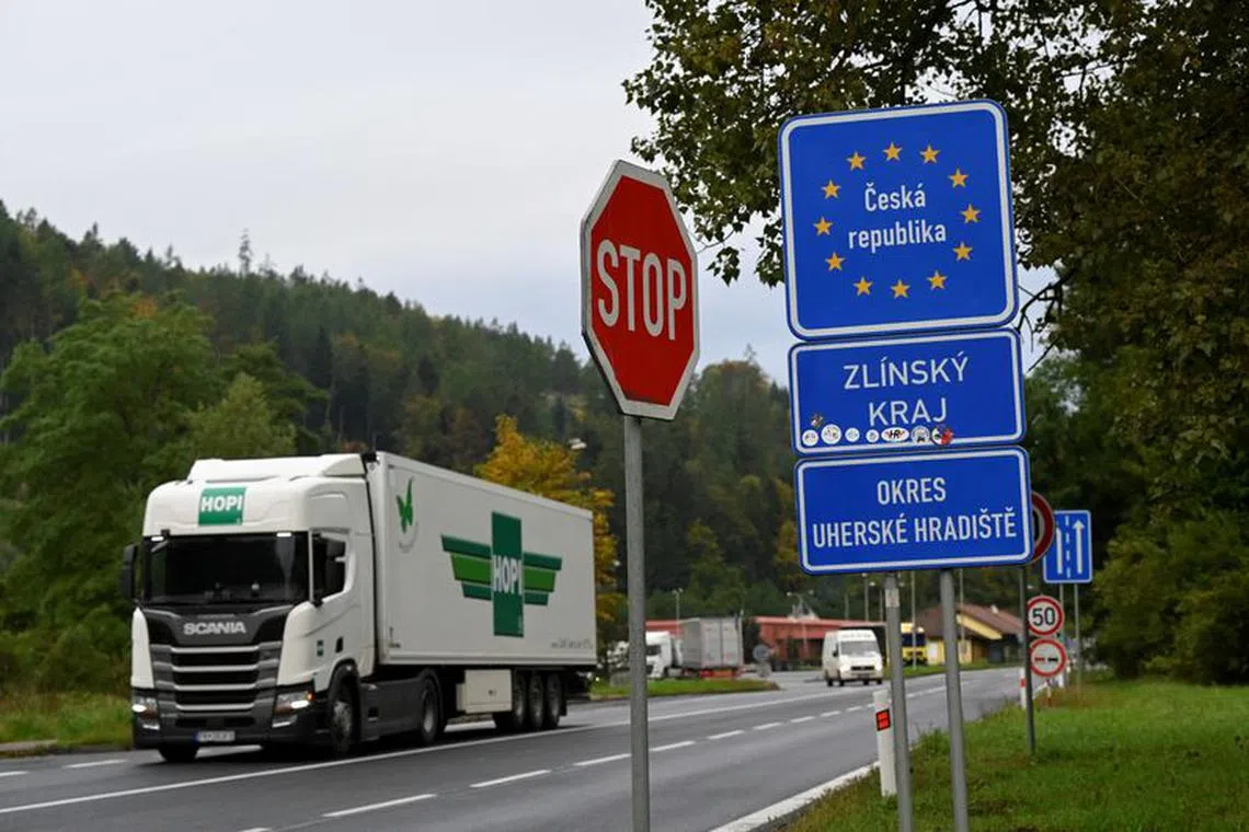 FILE PHOTO: A truck passes border plaques at Czech-Slovak border, while police officers proceed to check vehicles in Stary Hrozenkov, as part of the security measures that were put in place after the numbers of migrants travelling to Germany increased, Czech Republic, September 29, 2022.  REUTERS/Radovan Stoklasa