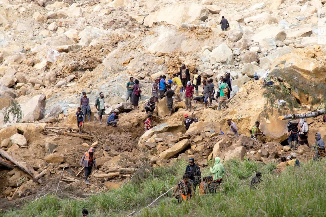 FILE PHOTO: People clear an area at the site of a landslide in Yambali village, Enga Province, Papua New Guinea, May 27, 2024.   UNDP Papua New Guinea/Handout via REUTERS/File Photo