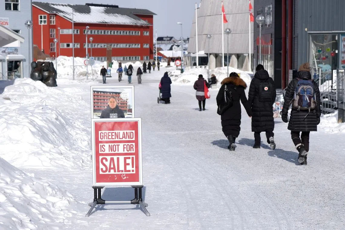 People walk past posters for candidates in the upcoming Danish elections in Nuuk, Greenland, March 17, 2026. REUTERS/Tim Barsoe