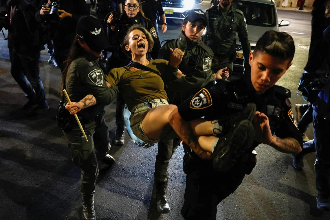 Police detain a woman during a protest against the government’s judicial reform programme, in Tel Aviv, on March 1, 2023.