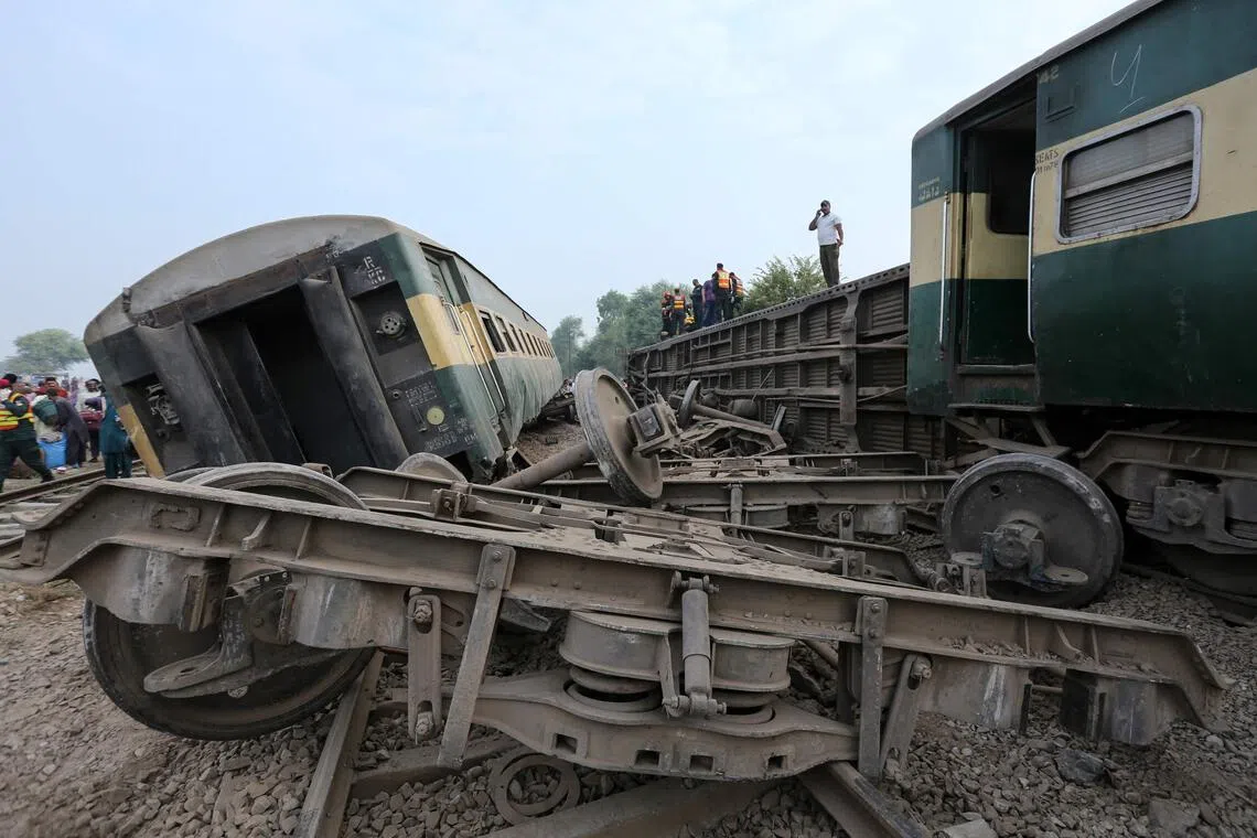 Rescue workers searching for victims following the derailment of the passenger train on the outskirts of Multan in Pakistan on Oct 13.