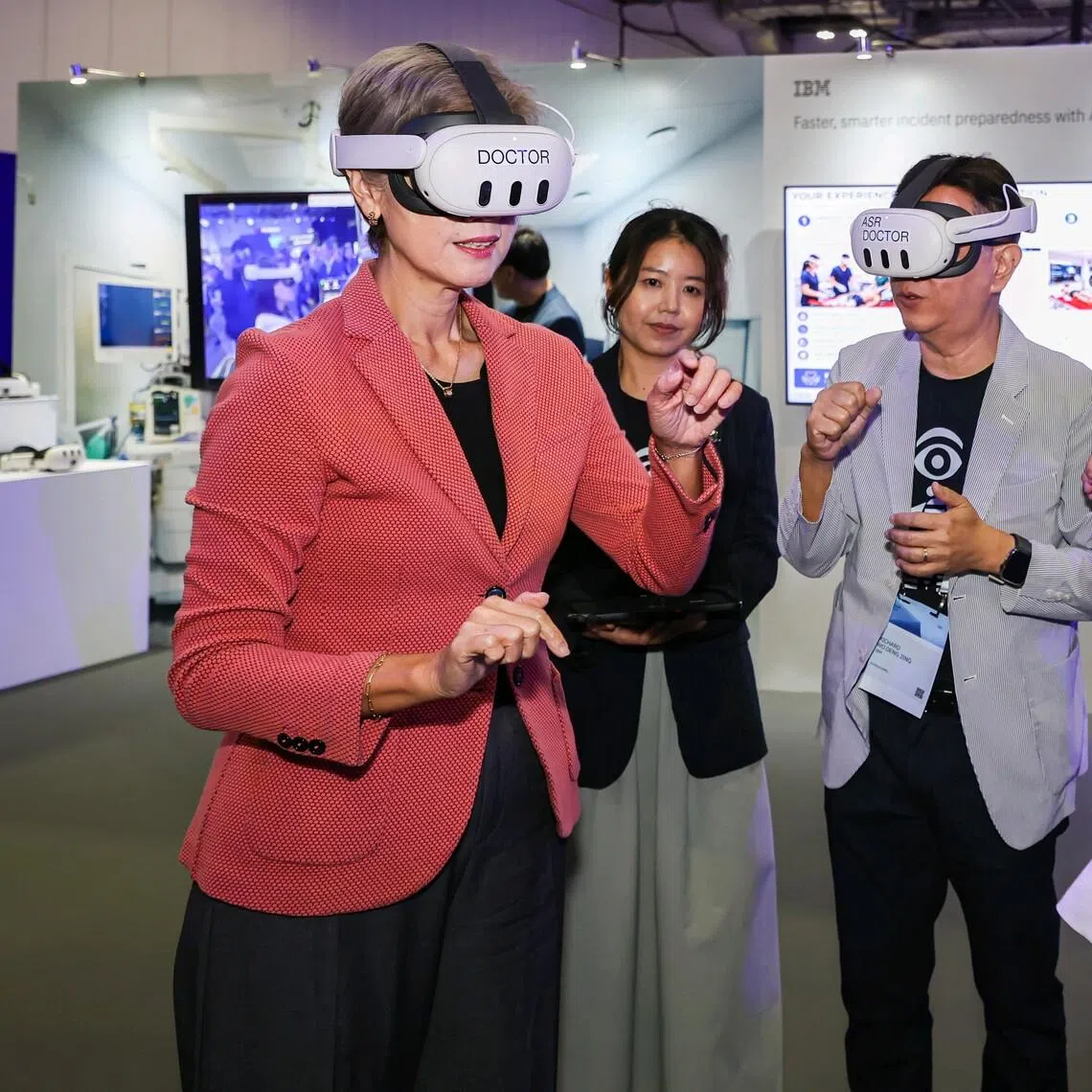 (From left) Minister for Digital Development and Information Josephine Teo, guided by IBM cognitive solution developer Richard Wo and IBM senior data scientist Ang Ai Kiar, trying IBM’s immersive mixed reality training solution, developed with Changi General Hospital, at the IBM Think Singapore conference on July 21.