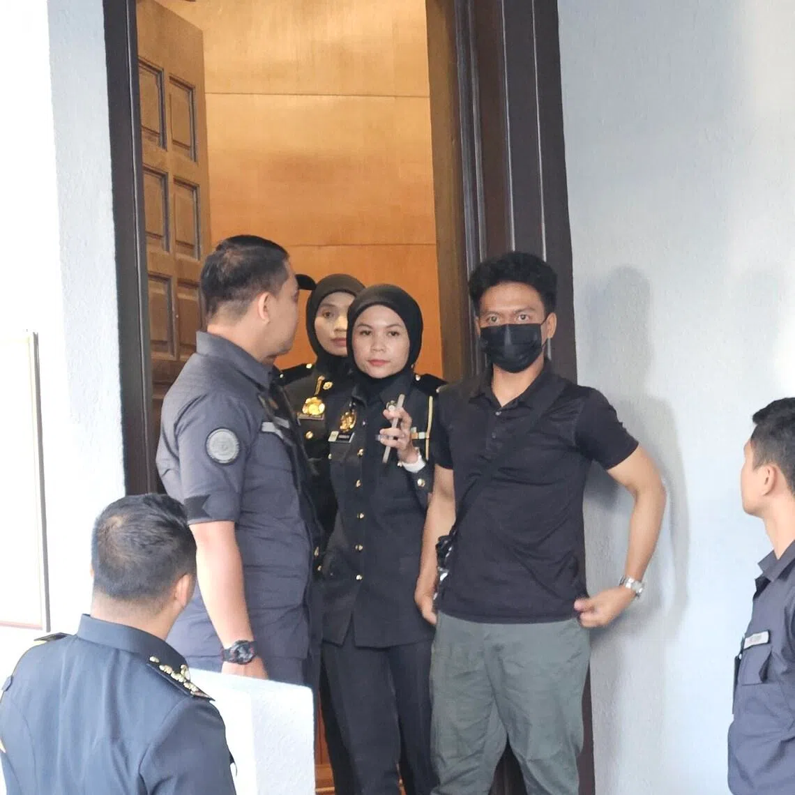 Singaporean Mohamed Nuh Qurasaini Kayat (wearing black mask) was fined and sentenced to 4 hours of community service for littering cigarette butt in Kuala Lumpur on Feb 9.