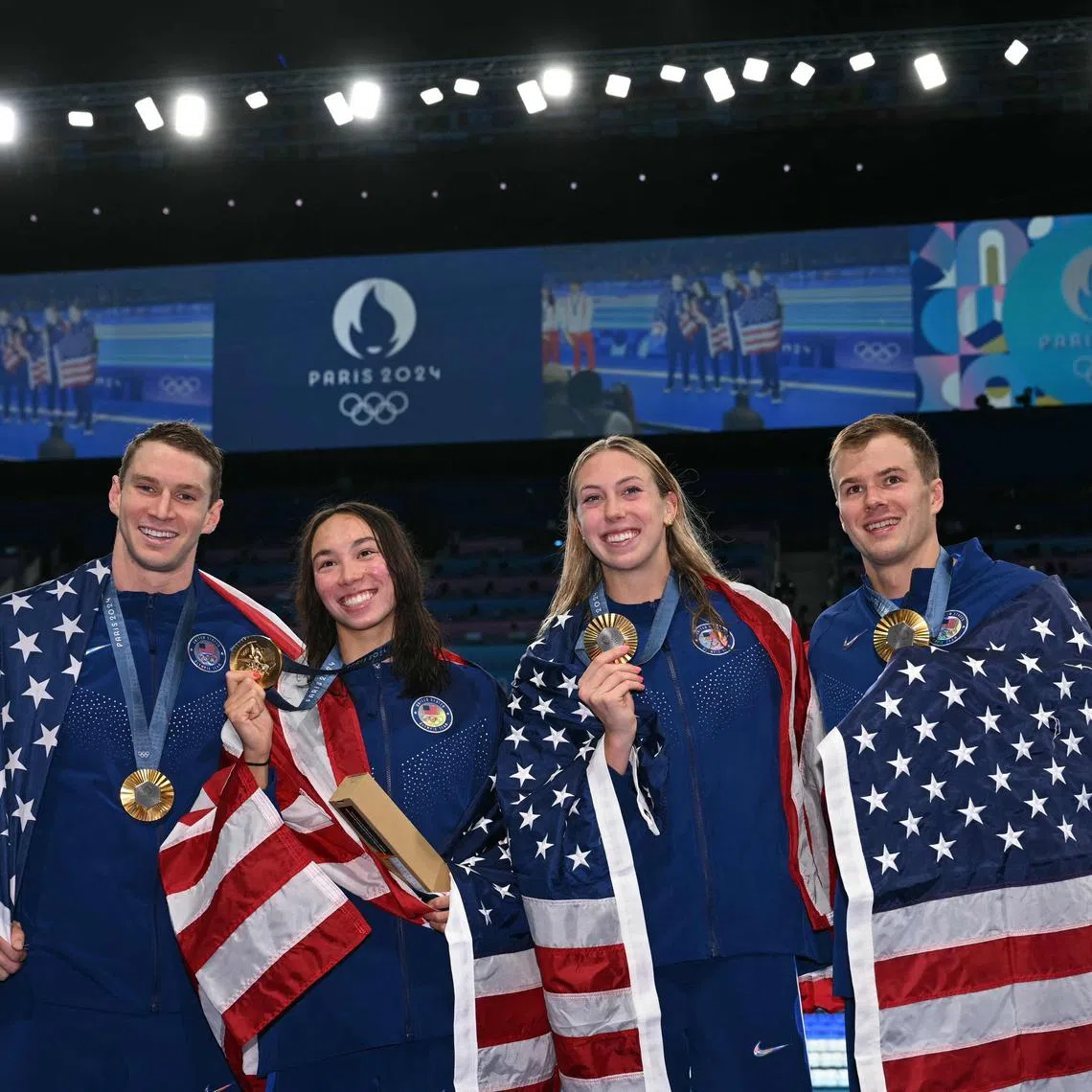 (L-R) Gold medallists Ryan Murphy, Torri Huske, Gretchen Walsh and Nic Fink celebrate during the podium ceremony of the mixed 4x100m medley relay final.