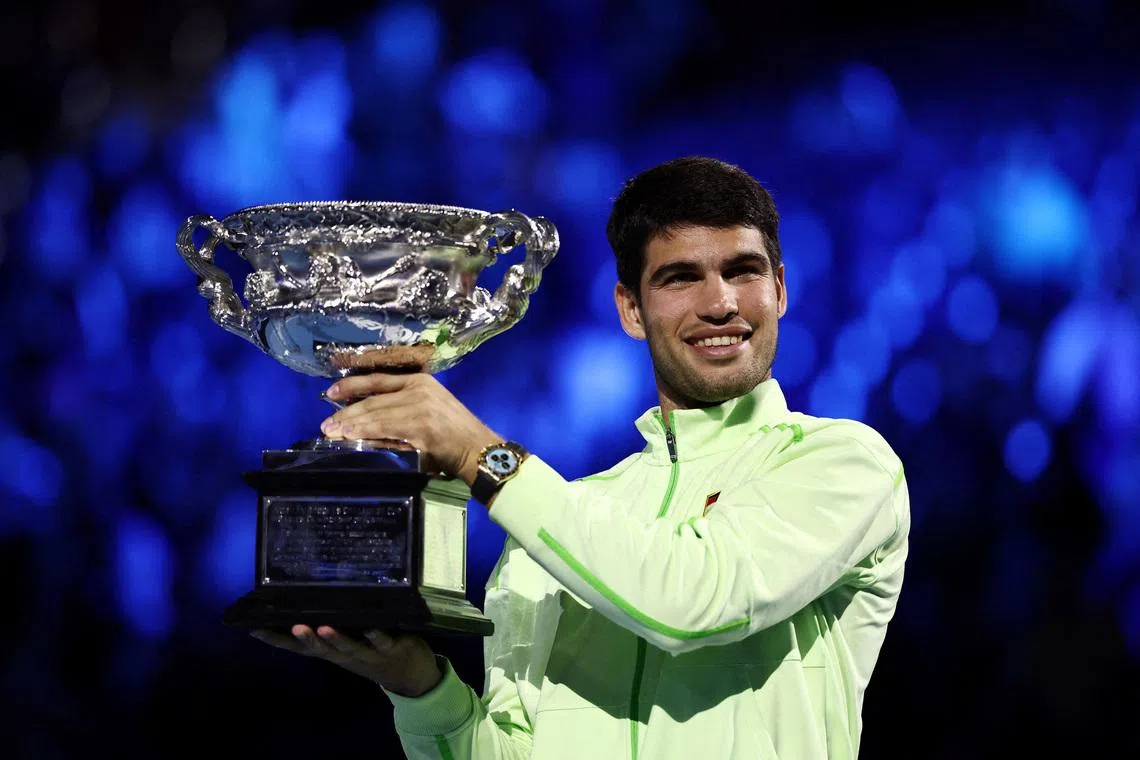 Tennis - Australian Open - Melbourne Park, Melbourne, Australia - February 1, 2026 Spain's Carlos Alcaraz celebrates with the trophy after winning the Australian Open men's singles against Serbia's Novak Djokovic. Alcaraz becomes the youngest man to win all four grand slam titles. REUTERS/Tingshu Wang