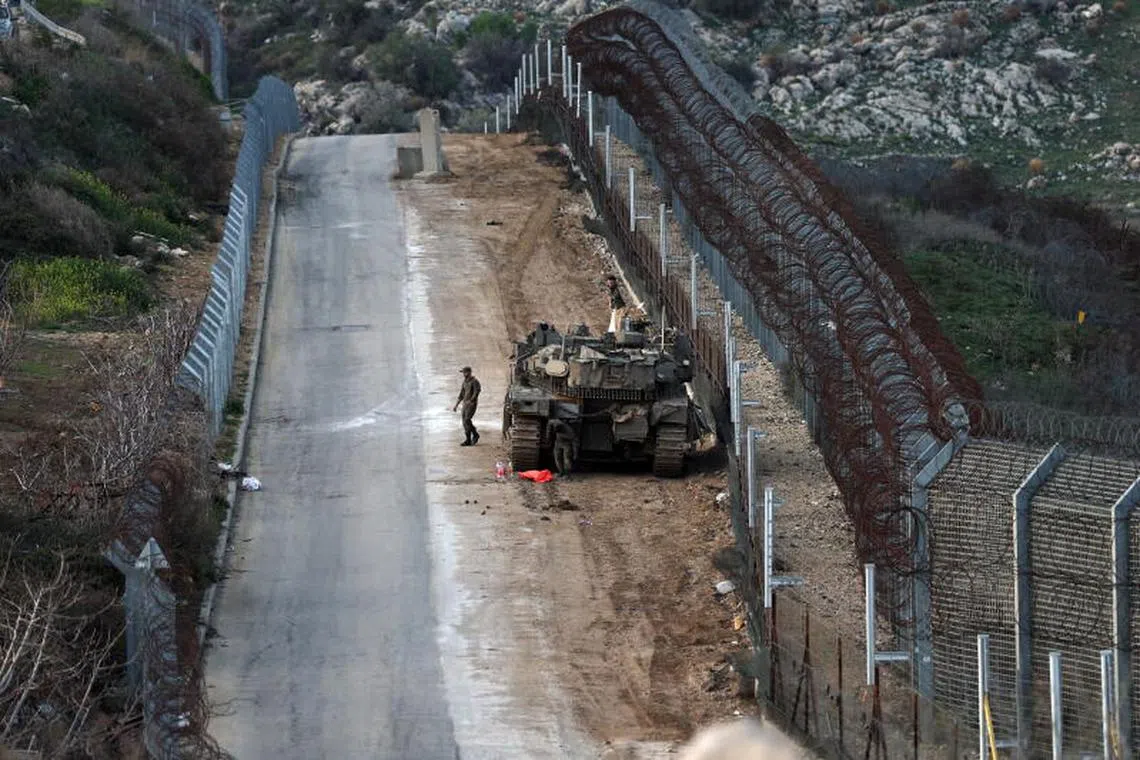 epa11970293 An Israeli tank patrolling along the security fence before entering the buffer zone between Israel and Syria, near the Druze Village of Majdal Shams, in the Israeli-annexed Golan Heights, 17 March 2025. Israel is boosting troop presence on the Golan Heights amid developments in Syria. EPA-EFE/ATEF SAFADI