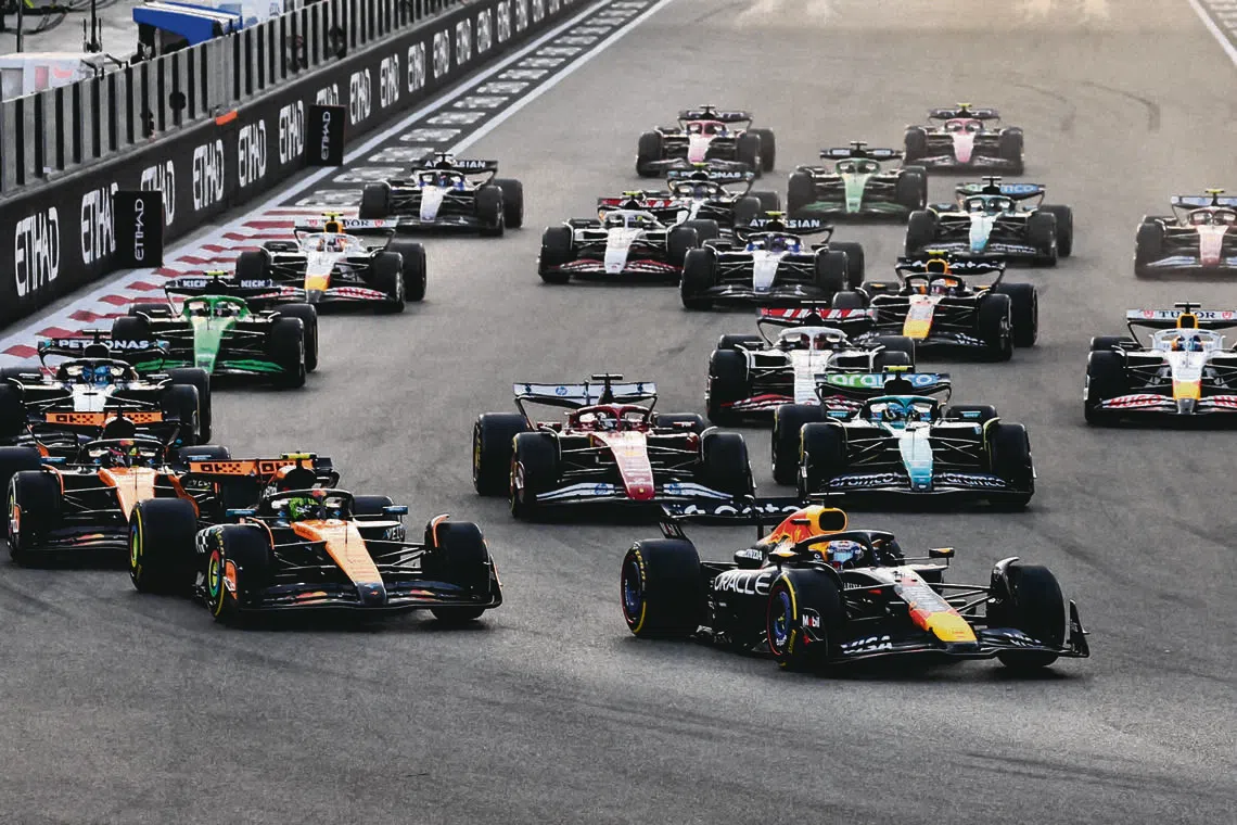 Red Bull's Max Verstappen leads into the first corner at the start of the race ahead of McLaren's Lando Norris during the 2025 Abu Dhabi Grand Prix.