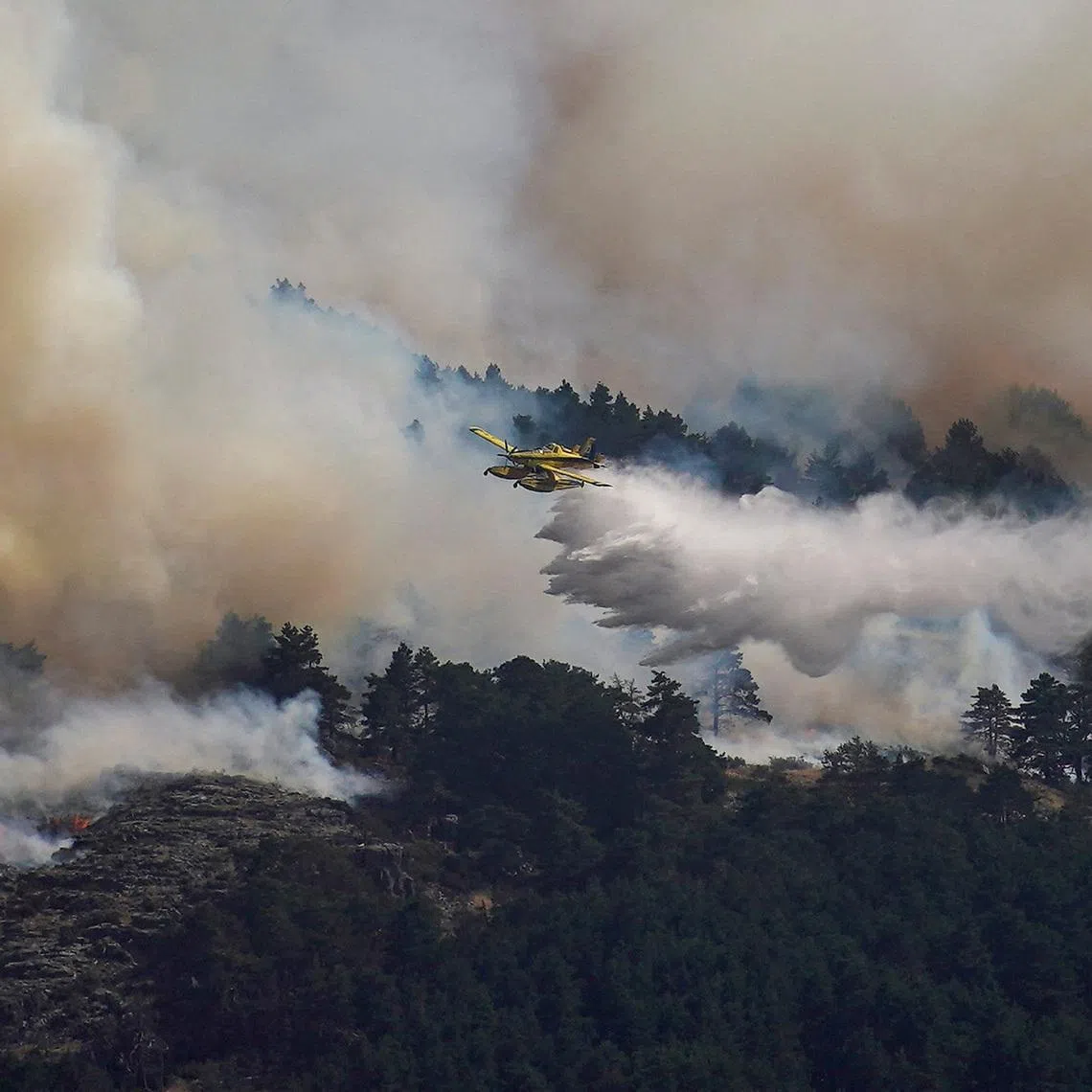 An airplane release water above the wildfire of La Mierla in Condemios de Arriba, Guadalajara, Spain July 22, 2026. REUTERS/Ana Beltran