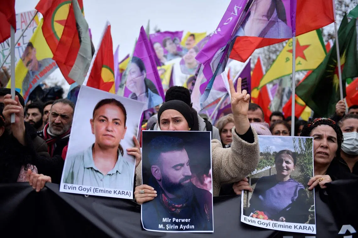 TOPSHOT - Supporters and members of the Kurdish community  hold portraits of victims Emine Kara and Mir Perwer during a demonstration a day after a gunman opened fire at a Kurdish cultural centre killing three people, at The Place de la Republique in Paris on December 24, 2022. - Emine Kara was a leader of the Kurdish Women's Movement in France and Mir Perwer, a political refugee and artist. The shots at the centre and a nearby hairdressing salon shortly before midday caused panic in the trendy 10th district of the French capital, a bustling area of shops and restaurants that is home to a large Kurdish population. The 69-year-old white French gunman told investigators he was racist, a source close to the case said. (Photo by JULIEN DE ROSA / AFP)