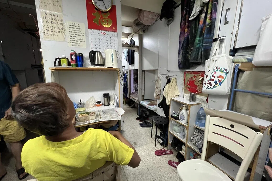 An odd-job worker has his dinner at the communal area of his “coffin home” in Cheung Sha Wan, Hong Kong.
