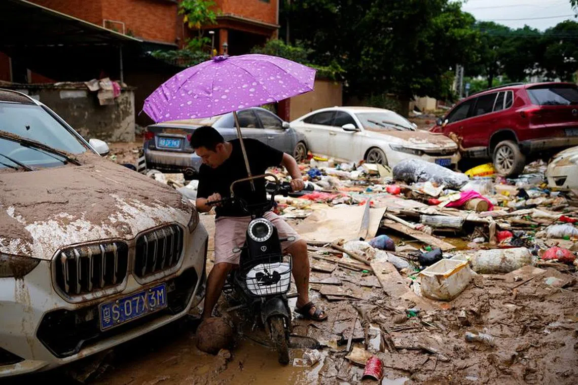 A man rides a scooter through mud and debris after heavy rainfall flooded Tangxia town in Dongguan, Guangdong province, China September 9, 2023. REUTERS/Aly Song