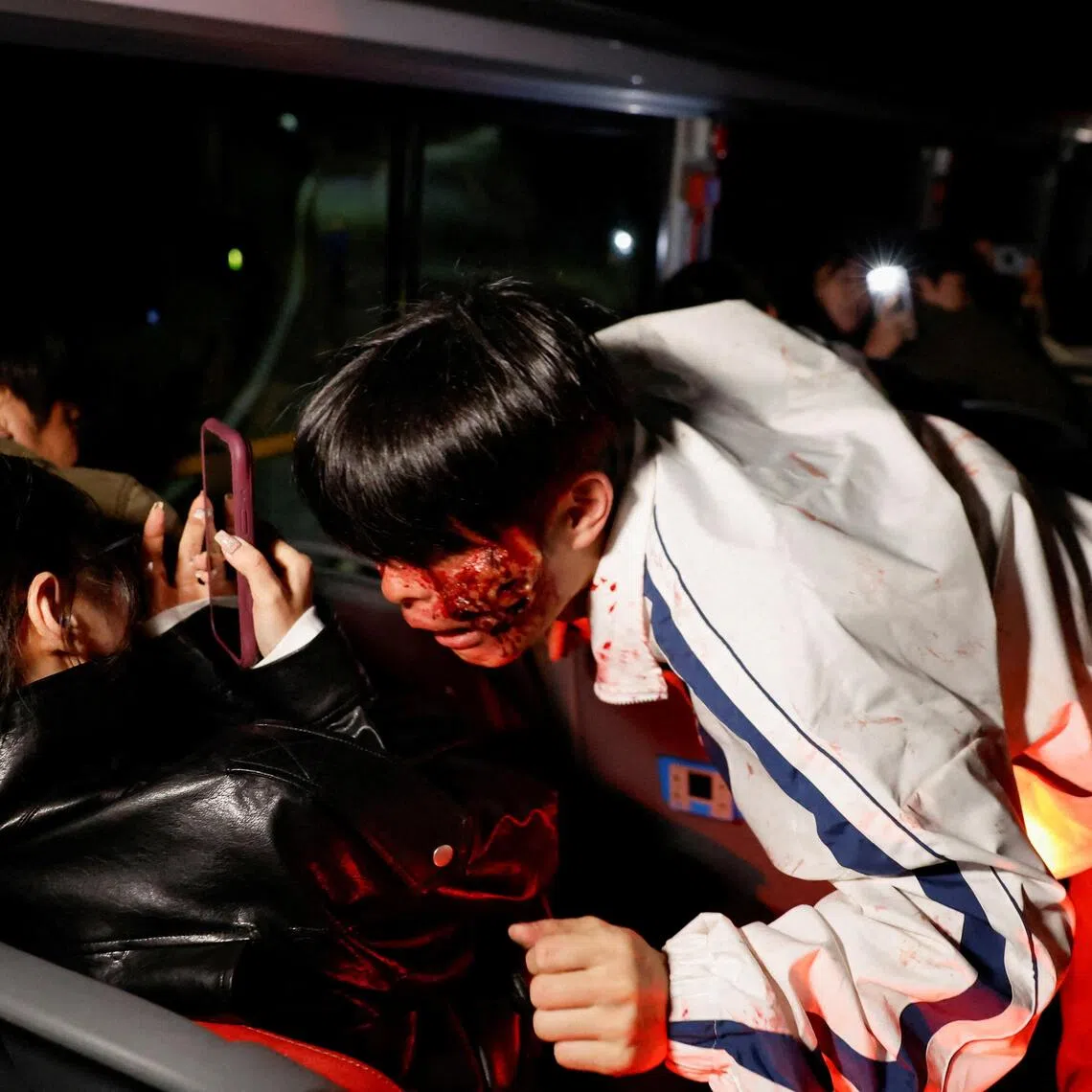 An actor dressed as a zombie leans towards a passenger aboard a bus during the Seoul City Tour Tiger Bus Zombie Attack event on Oct 21.